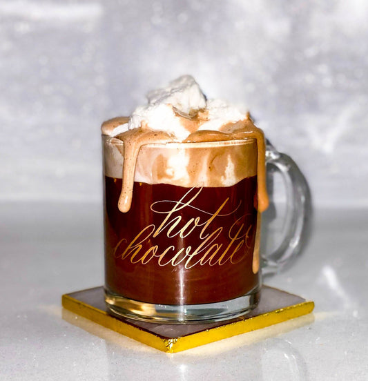 Gold hot chocolate calligraphy glass mug on a gold coaster